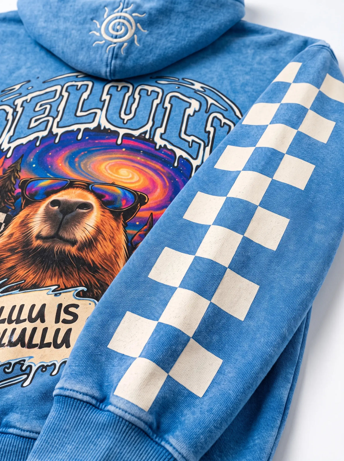 Close-up of the checkerboard sleeve on the Delulu Is Solulu acid wash hoodie